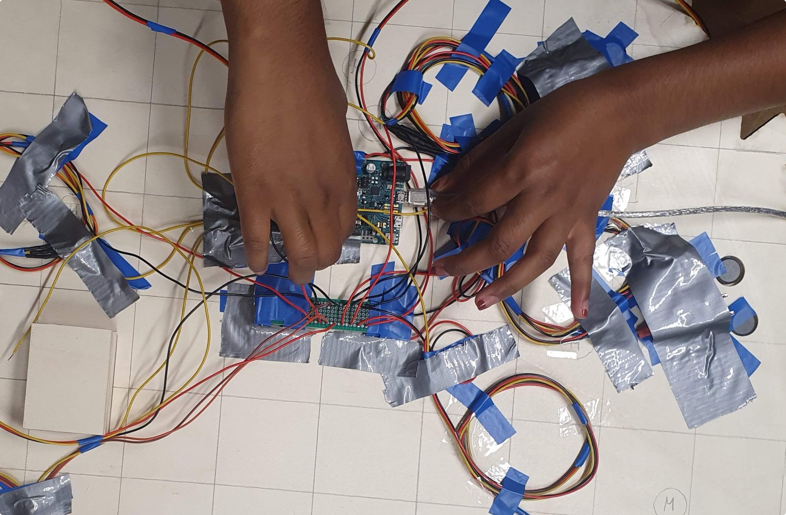 hands, who connect the arduino in the back of the exhibit